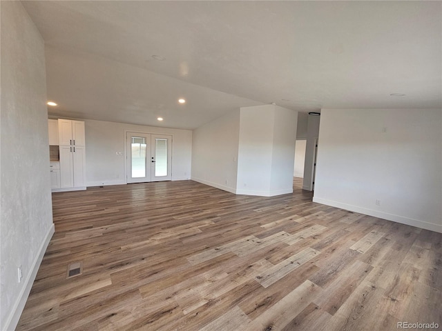 unfurnished living room with french doors and light hardwood / wood-style floors