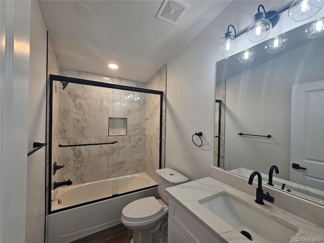 full bathroom with vanity, enclosed tub / shower combo, hardwood / wood-style flooring, and toilet