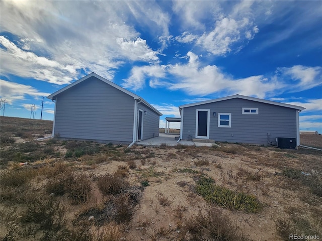 rear view of property featuring central air condition unit and a patio area