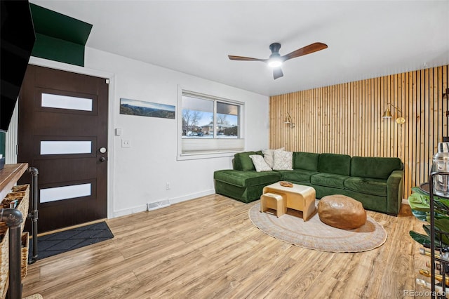 living room featuring ceiling fan and light hardwood / wood-style flooring