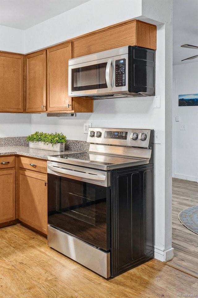 kitchen featuring appliances with stainless steel finishes and light hardwood / wood-style flooring