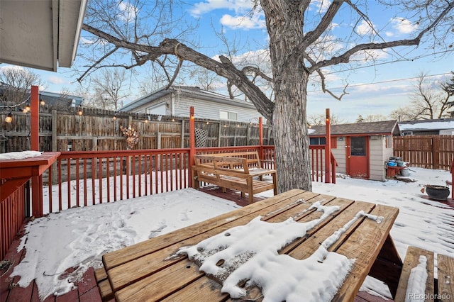 snow covered deck with a storage shed