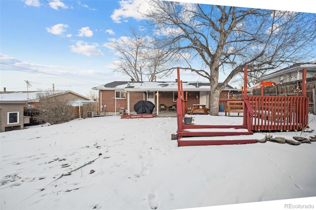 snow covered property with a deck