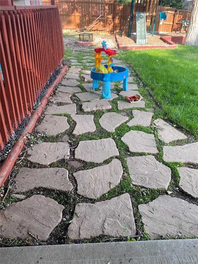 view of yard featuring a playground and a patio