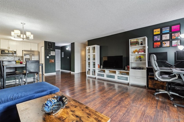 living room with a textured ceiling, a chandelier, and dark wood-type flooring