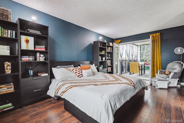 bedroom with a textured ceiling and dark hardwood / wood-style flooring