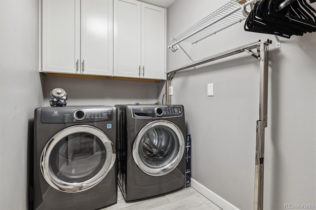 washroom featuring cabinets and washer and clothes dryer