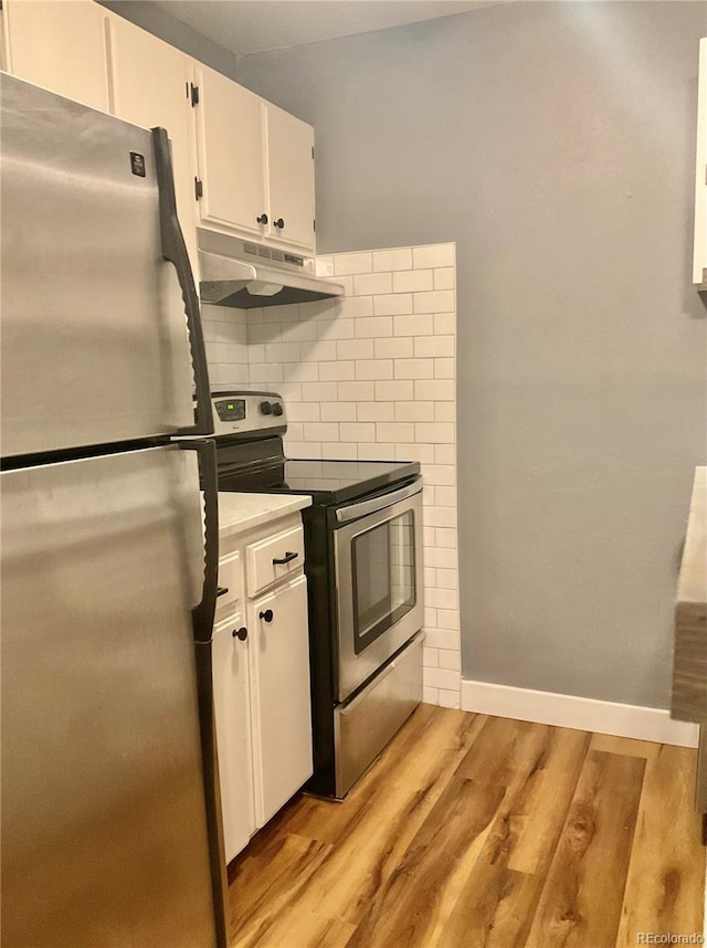 kitchen featuring tasteful backsplash, white cabinets, appliances with stainless steel finishes, and light hardwood / wood-style flooring