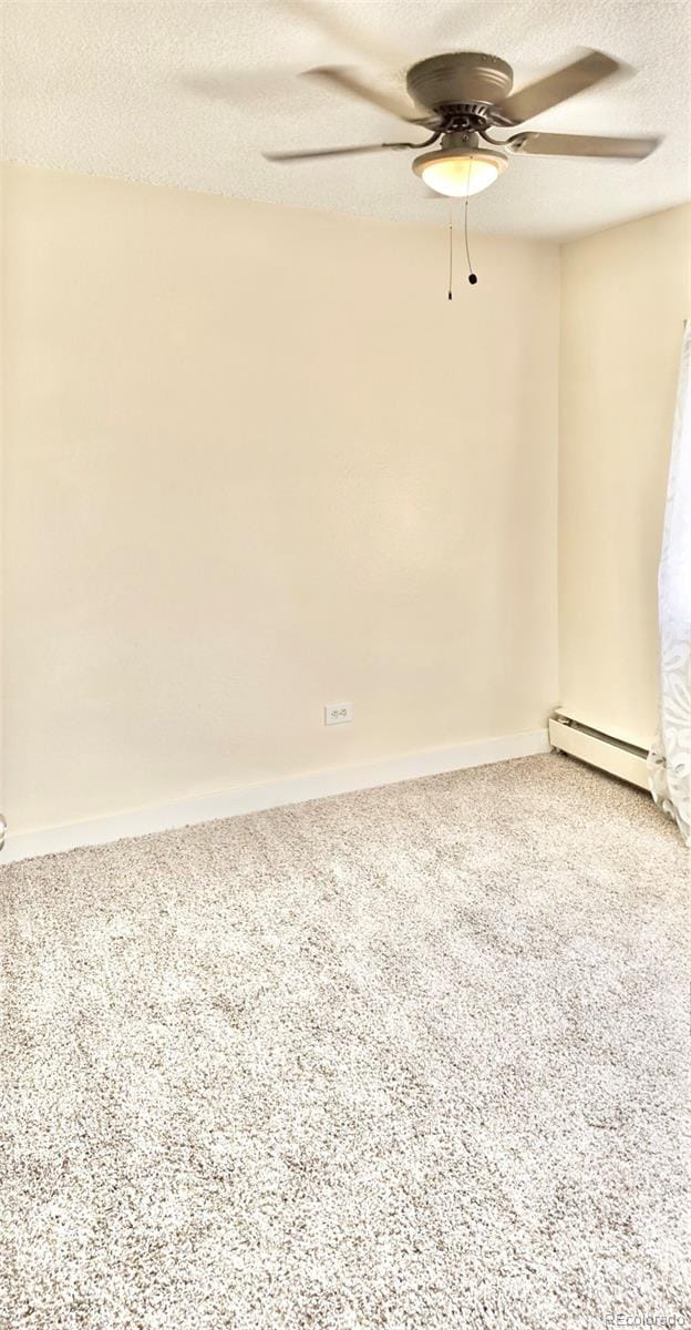 carpeted empty room featuring baseboard heating, ceiling fan, and a textured ceiling