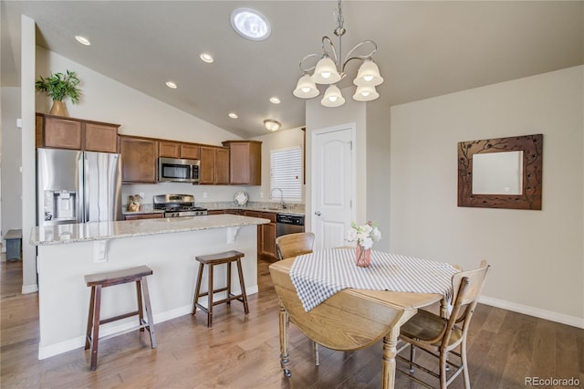 6812 Indian Paintbrush St, Frederick, CO 80530 - dining room with lofted ceiling, a chandelier, light wood-style flooring, recessed lighting, and baseboards