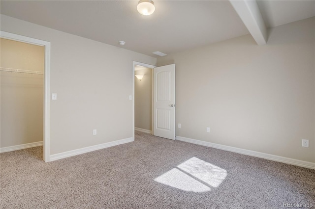 6812 Indian Paintbrush St, Frederick, CO 80530 - unfurnished bedroom featuring a walk in closet, carpet flooring, beamed ceiling, a closet, and baseboards