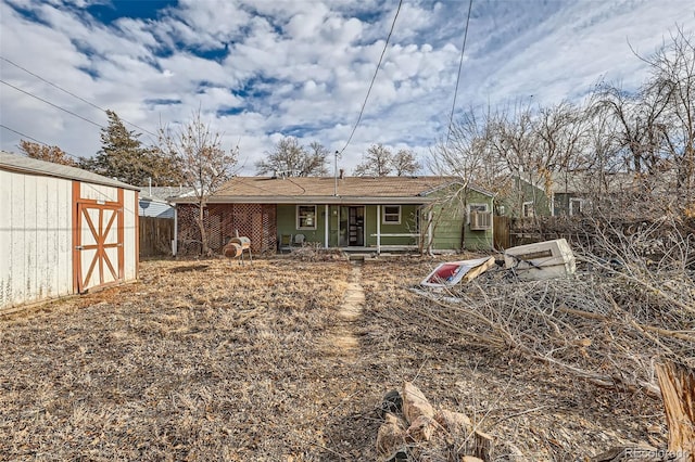 rear view of house featuring a shed