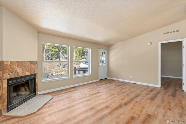 140 Beaver Rd, Idaho Springs, CO 80452 - unfurnished living room with a fireplace, a textured ceiling, plenty of natural light, light wood-style flooring, and baseboards