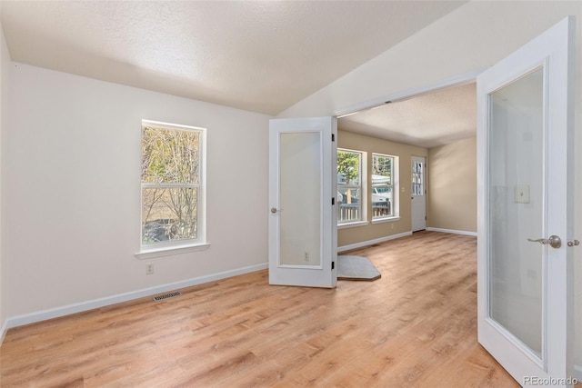 140 Beaver Rd, Idaho Springs, CO 80452 - unfurnished room featuring a textured ceiling, light wood-style flooring, baseboards, and french doors