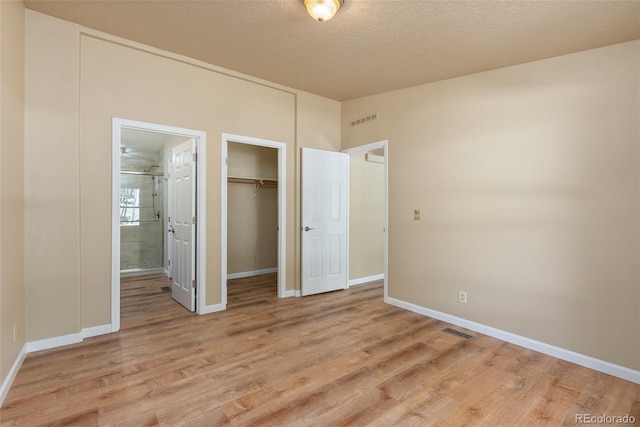 140 Beaver Rd, Idaho Springs, CO 80452 - unfurnished bedroom with light wood-type flooring, a closet, baseboards, ensuite bath, and a textured ceiling