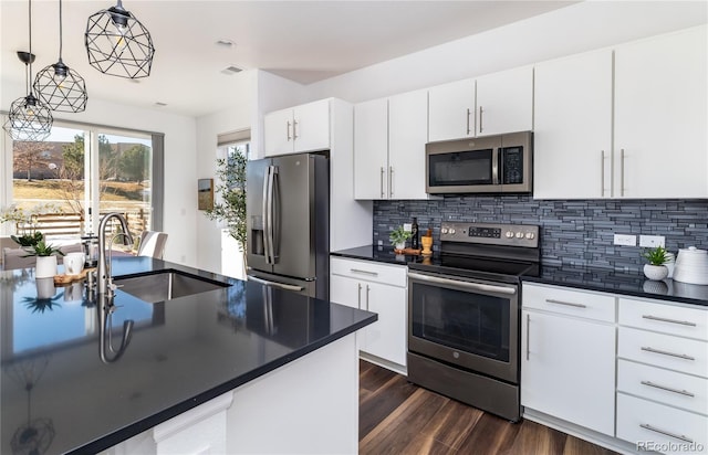 kitchen with pendant lighting, sink, appliances with stainless steel finishes, tasteful backsplash, and white cabinets