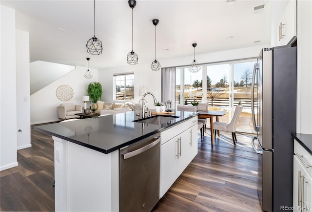 kitchen with pendant lighting, sink, stainless steel appliances, and white cabinets