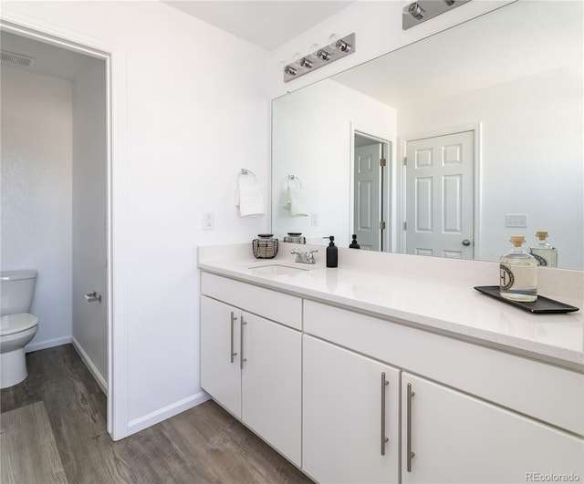 bathroom featuring vanity, hardwood / wood-style flooring, and toilet