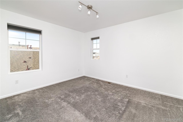 unfurnished room featuring carpet and track lighting