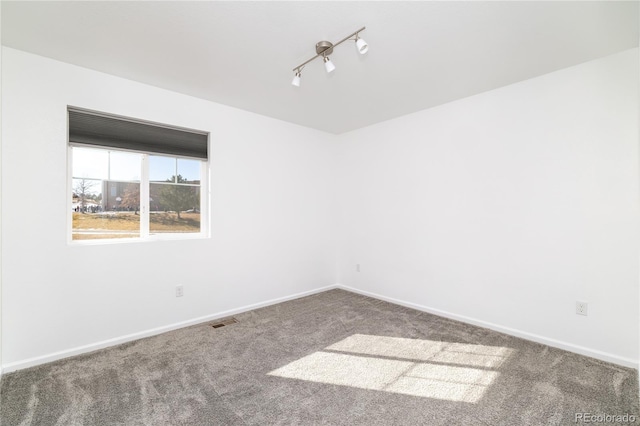 carpeted spare room with track lighting