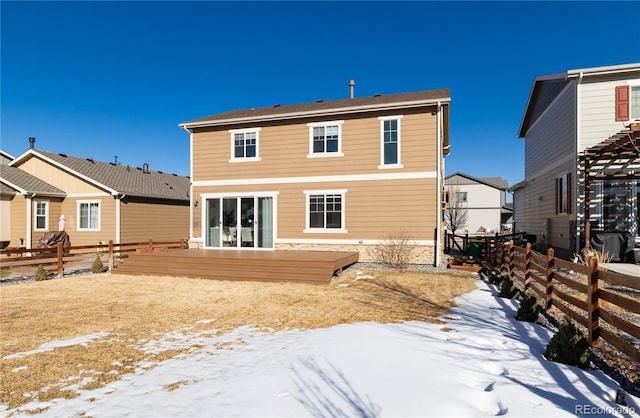 snow covered rear of property featuring a deck