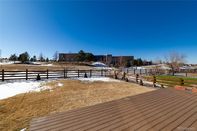 snow covered deck featuring a rural view