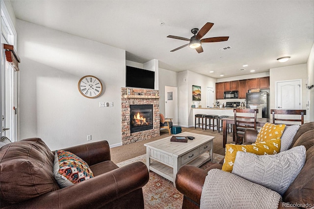 living area with carpet floors, a fireplace, visible vents, ceiling fan, and baseboards