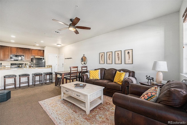 carpeted living area with ceiling fan and visible vents