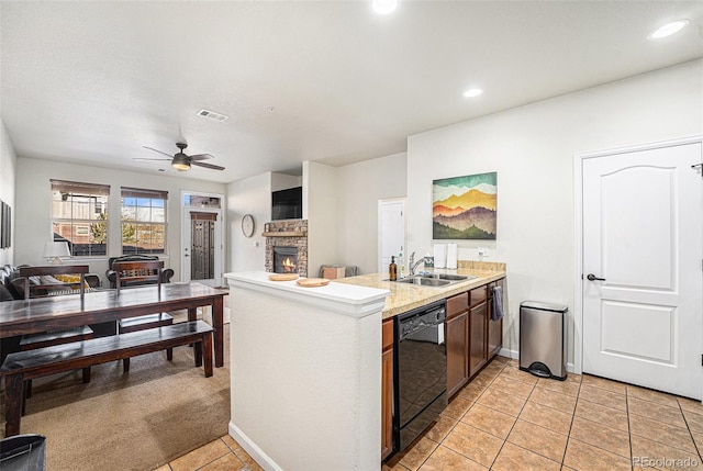 kitchen with a fireplace, a sink, visible vents, black dishwasher, and open floor plan