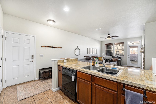 kitchen featuring black dishwasher, light tile patterned floors, brown cabinetry, ceiling fan, and a sink