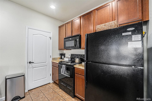 kitchen with black appliances, brown cabinetry, light countertops, and light tile patterned flooring