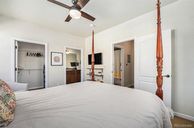 bedroom featuring a closet, a spacious closet, connected bathroom, ceiling fan, and baseboards