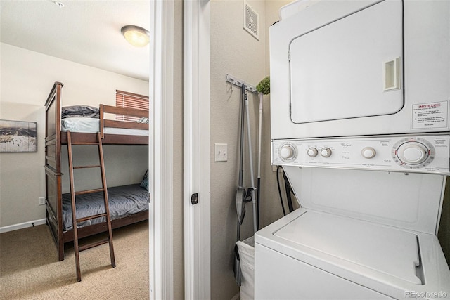 laundry room with light colored carpet, laundry area, visible vents, baseboards, and stacked washing maching and dryer