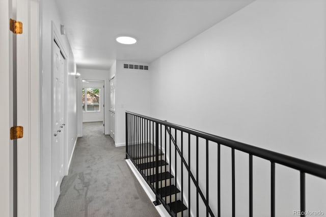 hallway with light colored carpet