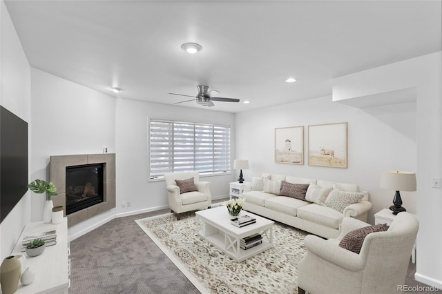 carpeted living room with a tiled fireplace and ceiling fan