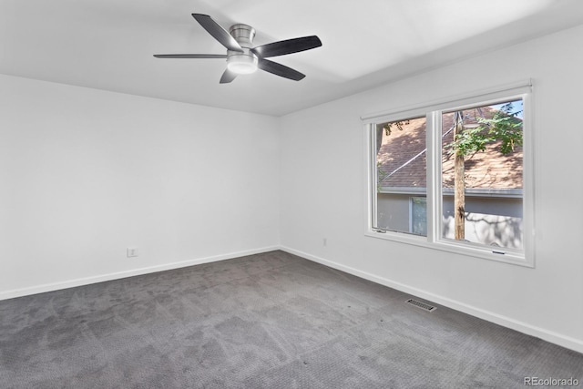 empty room with dark colored carpet and ceiling fan