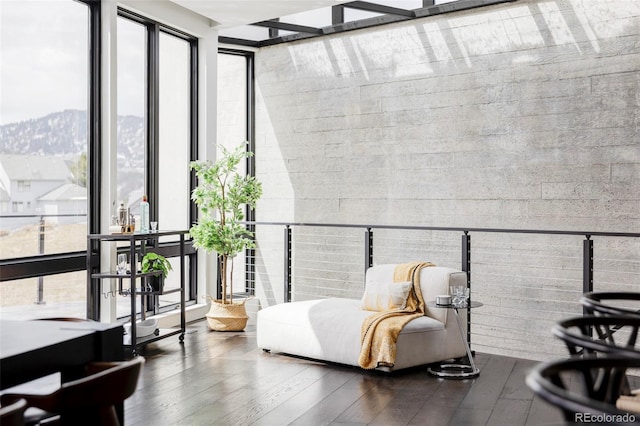 interior space with floor to ceiling windows, wood finished floors, and a mountain view