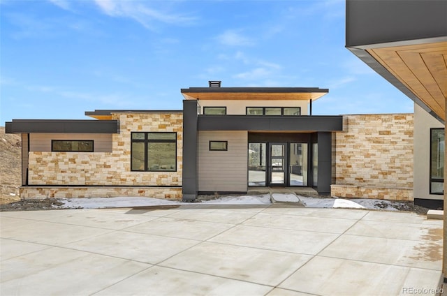 rear view of property with stone siding