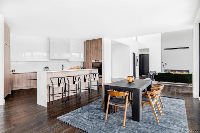 dining space with dark wood-style flooring