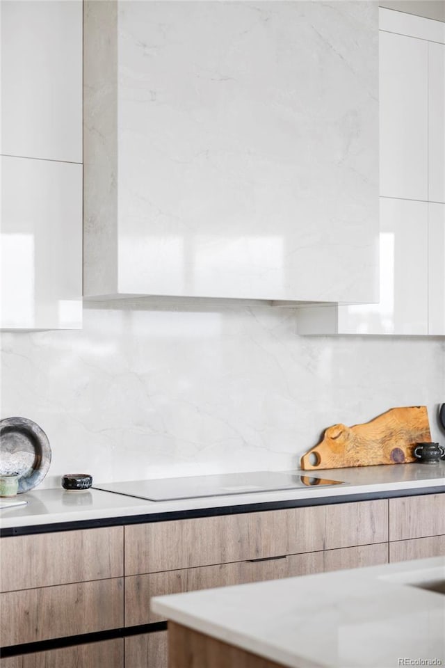 room details with black electric cooktop and decorative backsplash