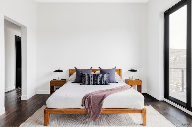 bedroom with hardwood / wood-style floors and baseboards