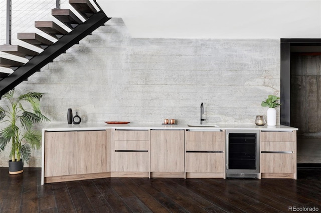 bar with stairs, dark wood-style flooring, wine cooler, a sink, and indoor wet bar