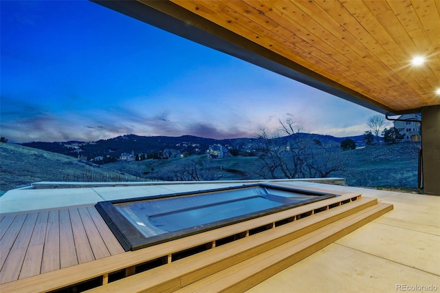 exterior space featuring a mountain view and an outdoor hot tub