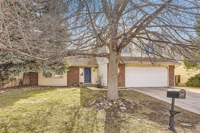 view of front of house featuring fence, an attached garage, concrete driveway, a front lawn, and brick siding