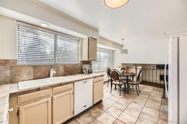 kitchen featuring tile countertops, decorative light fixtures, white appliances, light tile patterned flooring, and a sink