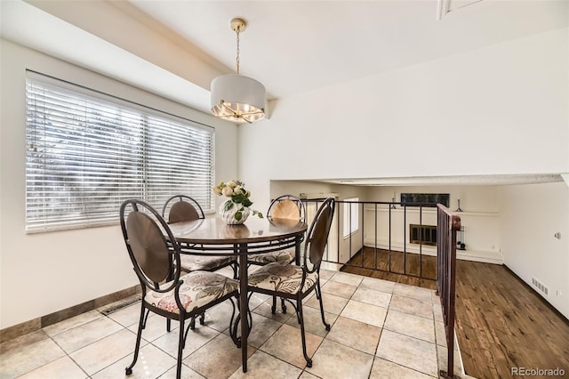 dining space featuring light tile patterned flooring, a notable chandelier, baseboards, and visible vents