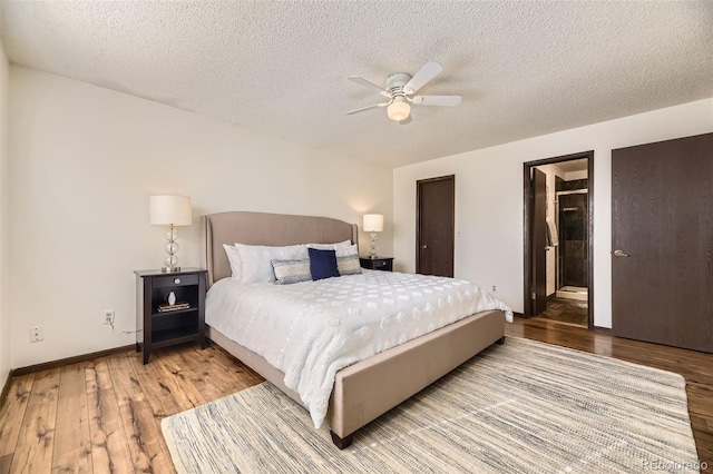bedroom featuring ceiling fan, a textured ceiling, baseboards, and wood finished floors