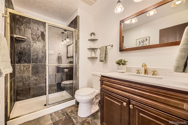 full bathroom with a stall shower, vanity, toilet, and a textured ceiling