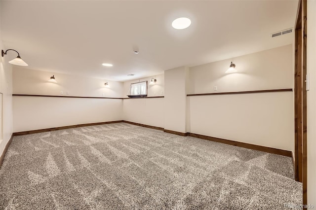 below grade area with baseboards, visible vents, and carpet