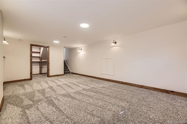 finished basement with stairway, light carpet, and baseboards